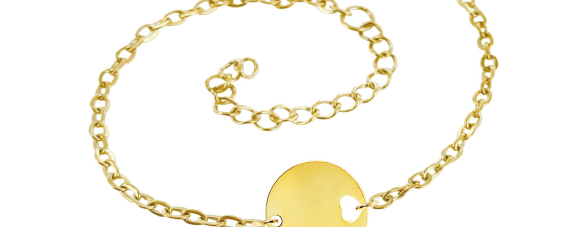 Bracelet chaînette agrémenté d'une médaille ronde avec cœur ajouré en acier inoxydable doré